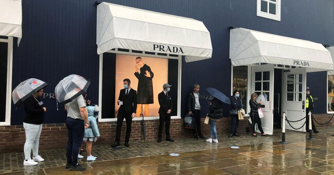 FILE PHOTO: Shoppers are seen queuing outside the Prada shop at Bicester Village, in Bicester, Britain, June 18, 2020.   REUTERS/Eddie Keogh/File Photo