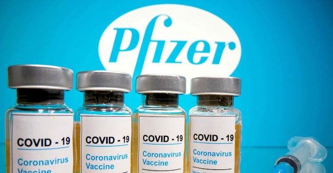 FILE PHOTO: Vials with a sticker reading, "COVID-19 / Coronavirus vaccine / Injection only" and a medical syringe are seen in front of a displayed Pfizer logo in this illustration taken October 31, 2020. REUTERS/Dado Ruvic/File Photo