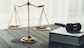 Symbolizing justice and legal authority, golden balanced scale and gavel on desk with law book in lawyer office background, reflecting concept of equality and fair judgment. equility