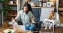 Mother working on laptop and talking on computer webcam video call communication with business partners while baby playing. Woman work from home and caring for kids.