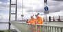 Bridge workers on parapet of suspension bridge. The Humber Bridge, UK was built in 1981 and at the time was the world's largest single-span suspension bridge