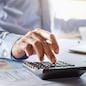 accountant working on desk using calculator for calculate finance report in office