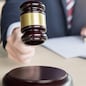 Male Judge In A Courtroom Striking The Gavel on sounding block.