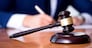 Handsome judge with gavel sitting in courtroom