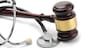 Close up of stethoscope and gavel on white background