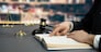 Closeup lawyer or attorney preparing for lawsuit or litigation, reading or studying on legal book on his desk at library for educational law school concept, decorated with legal symbols. Equilibrium