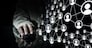 Close up view businessman hand using computer mouse on reflective black surface and networking concept on dark background