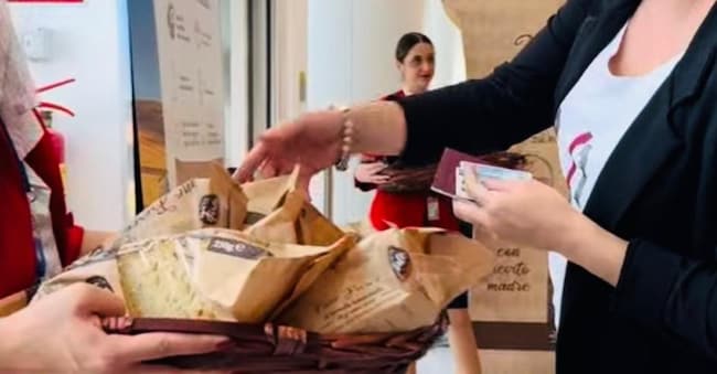 Aeroporto di Bari, una passeggera mentre riceve una confezione di pane di Altamura
