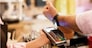 Person paying at cafe with smart watch wirelessly on POS terminal