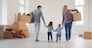 Happy family with children moving with boxes in a new apartment house. Relocation concept new house apartment rental housing.