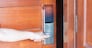 man holding handle of smart digital door lock while open or close the door. Technology, electrical and lifestyle concepts