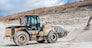 Wheel loader with large bucket on construction site or quarry. Mining heavy machinery details. Earthmoving, excavations, digging on soils. High quality photo