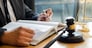 Male lawyer working with contract papers and reading law book in a courtroom, justice and law concept while presiding over trial