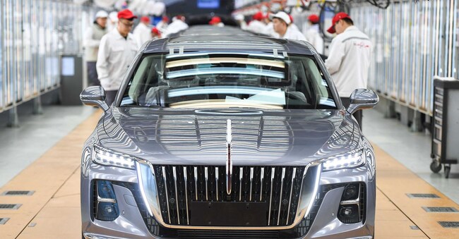 I dipendenti controllano le auto assemblate in un'officina della casa automobilistica FAW Hongqi a Changchun
