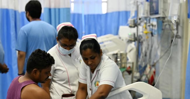 Nurses provide medical care to a patient at a special ward for heat stroke patients at a government hospital in Chennai on May 7, 2024. (Photo by R.Satish BABU / AFP)