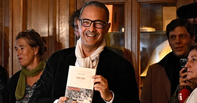 Vincitore del premio letterario Prix Goncourt, lo scrittore algerino Kamel Daoud (C) posa dopo essere stato premiato per il suo romanzo “Houris” al ristorante Drouant di Parigi, il 4 novembre 2024. (Photo by Julien De Rosa / AFP)