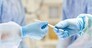surgery, medicine and people concept - close up of surgeons hands with scalpel at operation in operating room at hospital