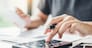 Man using calculator Accounting Calculating Cost Economic bills with money stack step growing growth saving money in home , finance concept