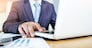 Working process startup. Businessman working with new finance project at office with laptop, tablet and graph data documents on his desk