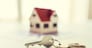mortgage, investment, real estate and property concept - close up of home model, money and house keys