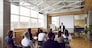 Team of people having class with business trainer. Group of male and female employees sitting at desks in modern office and listening to lecture by experienced teacher sharing knowledge and guidance