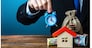 A man holds an alarm clock over the house and money. Limited offer. Rental business. Favorable terms and conditions, low interest rate. The right time on the real estate market to purchase a home.