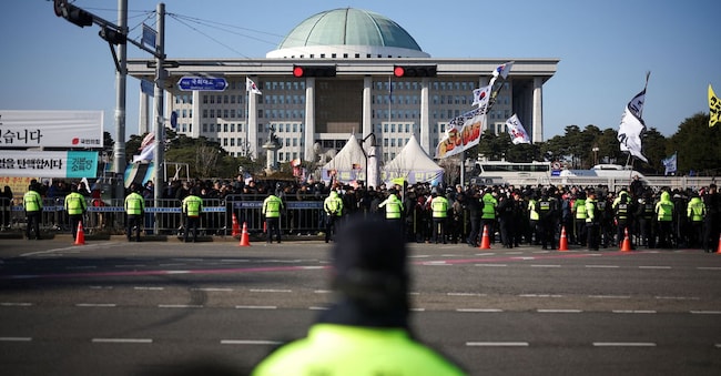 Un gruppo di manifestanti che chiede le dimissioni del presidente Yoon Suk Yeol, davanti all’Assemblea nazionale