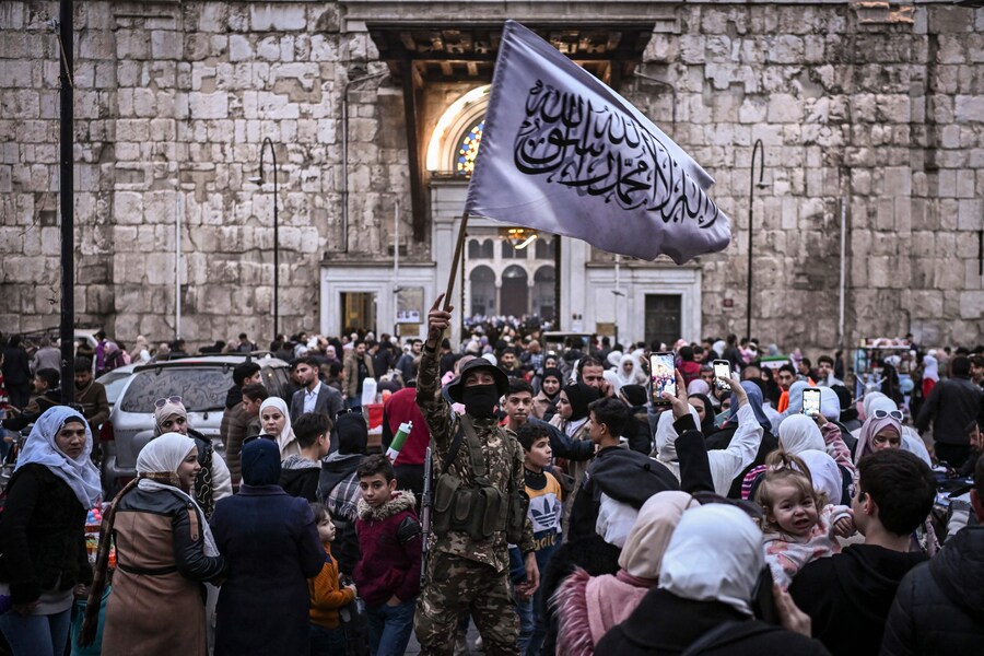 Un combattente sventola una bandiera islamica nel mercato Hamidiyeh nella città vecchia di Damasco l’11 dicembre 2024. I ribelli guidati dagli islamisti hanno preso Damasco con un’offensiva lampo l’8 dicembre, spodestando il presidente Bashar al-Assad e ponendo fine a cinque decenni di dominio Baath nel Siria. Photo by Aris MESSINIS / AFP (AFP)