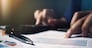 Close up pen on paperwork and woman hand calculate finance.