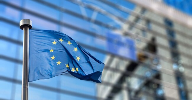 European Union flags in front of the blurred European Parliament in Brussels, Belgium