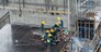 Aerial view of busy industrial construction site workers with cranes working. Top view of development high rise architecture building at noon.