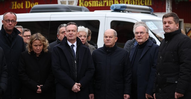TOPSHOT - German Chancellor Olaf Scholz (3R), State Premier of Saxony-Anhalt Reiner Haseloff (2R), German Minister for the Environment, Nature Conservation, Nuclear Safety and Consumer Protection Steffi Lemke (2L), German Minister for Transport and Digital Affairs and of Justice Volker Wissing (3L) and leader of Germany's  Christian Democratic Union (CDU) Friedrich Merz (L) visit the site of a car-ramming attack on a Christmas market in Magdeburg, eastern Germany, on December 21, 2024, resulting in several deaths and dozens of injured. German media reports that the death toll has risen to four over night and up to 200 injured in the attack on December 20th. (Photo by Ronny HARTMANN / AFP)