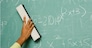 Person removing formulas from the blackboard