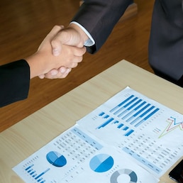 Business executives handshaking agreement project deal at a office