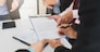 Businessman offering contract paper to his business partner for sign contract.