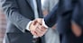 closeup of handshake of business partners on the background of business team