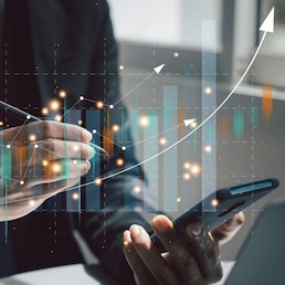 Man using mobile apps to monitor stock market analysis and trading activities on his laptop. Forex trading and investment growth concept. checking stock market graph report