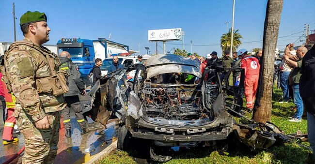 Lebanese army, security forces, and civil defence first responders inspect the remains of a destroyed vehicle that was reportedly hit by an Israeli strike in Lebanon's southern city of Sidon on February 17, 2025. Lebanese official media said the strike killed one person, a day ahead of a deadline in a ceasefire between Israel and Hezbollah. "A body... was retrieved from the car that was targeted by the Israeli strike" in Sidon, "after firefighters extinguished the fire", the official National News Agency said. (Photo by AFP)
