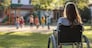 back view young girl in a wheelchair looking longingly at children playing in the schoolyard --ar 2:1 --v 6.1 Job ID: 28de474a-a289-4fd0-986c-1157fbf56a68