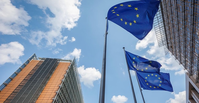 epa11483897 European Union flags flutter in front of the European Commission Berlaymont building (L), in Brussels, Belgium, 17 July 2024. The European Parliament is scheduled to vote on 18 July on Ursula von der Leyen's second term as EU Commission President. EPA/OLIVIER MATTHYS