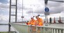 Bridge workers on parapet of suspension bridge. The Humber Bridge, UK was built in 1981 and at the time was the world's largest single-span suspension bridge