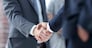 closeup of handshake of business partners on the background of business team