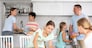 Parents and their four kids cleaning up their kitchen room together