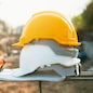white and yellow helmet on steel in construction site