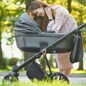 family, child and parenthood concept - happy mother walking with baby stroller in park.