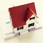 building, mortgage, investment, real estate and property concept - close up of home or house model and money