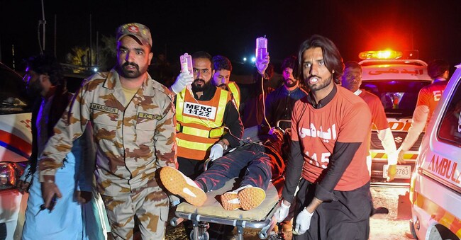 Militari e volontari impegnati nei soccorsi delle vittime dell’attacco al treno diretto a Peshawar da Quetta