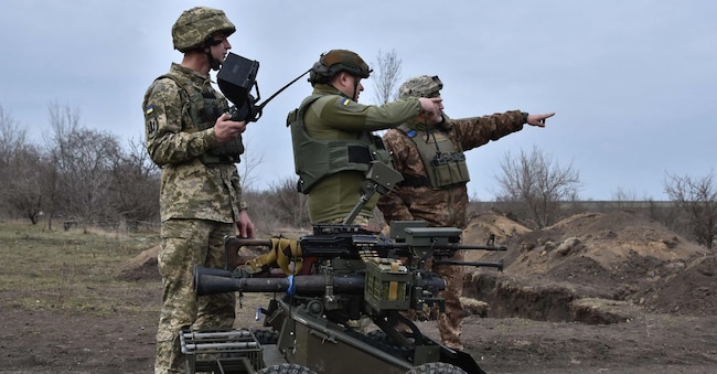 Questa foto di repertorio scattata e rilasciata dal servizio stampa della 65a Brigata meccanizzata delle Forze armate ucraine mostra dei militari ucraini che esaminano un veicolo senza pilota in un campo di addestramento militare nella regione di Zaporizhzhia il 13 marzo 2025, durante l’invasione russa dell’Ucraina. (Foto di Andriy ANDRIYENKO / 65a Brigata meccanizzata delle Forze armate ucraine / AFP)