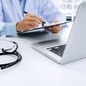 doctor working on laptop with  stethoscope and paper clipboard, selective focus
