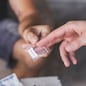 Drug dealer selling ecstasy pills to a drug addict